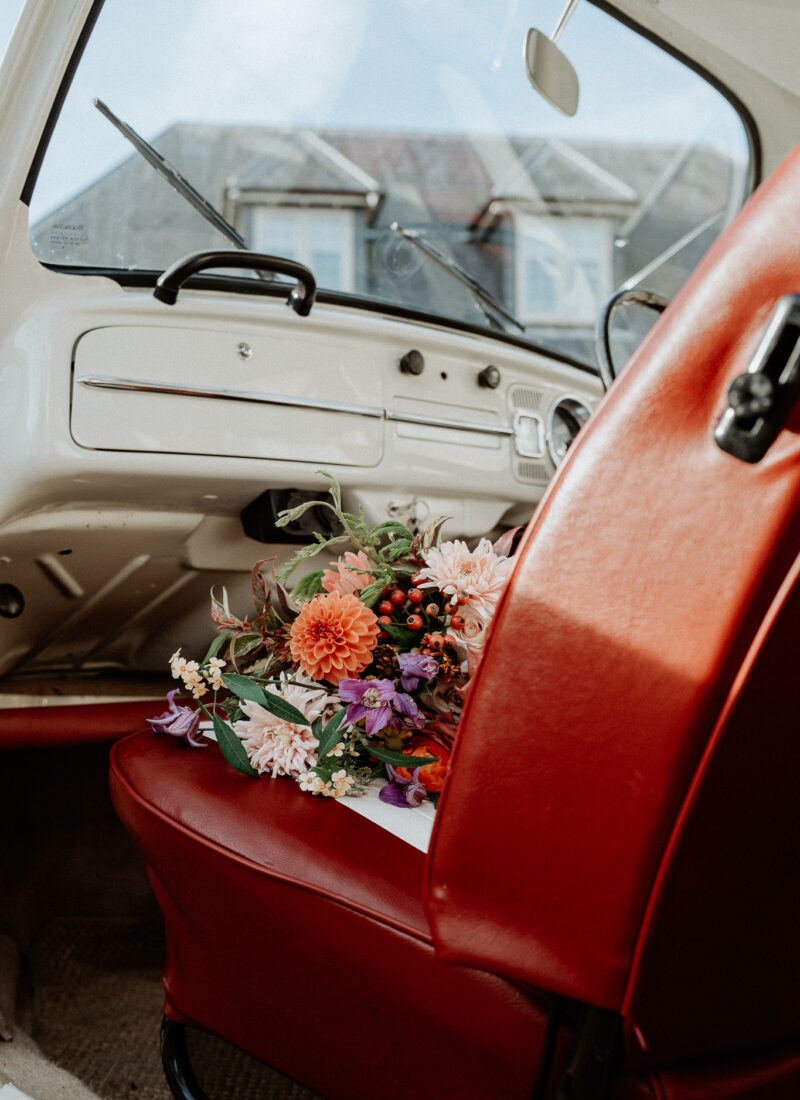 Bridal bouquet sitting on the front seat of a vintage VW camper.