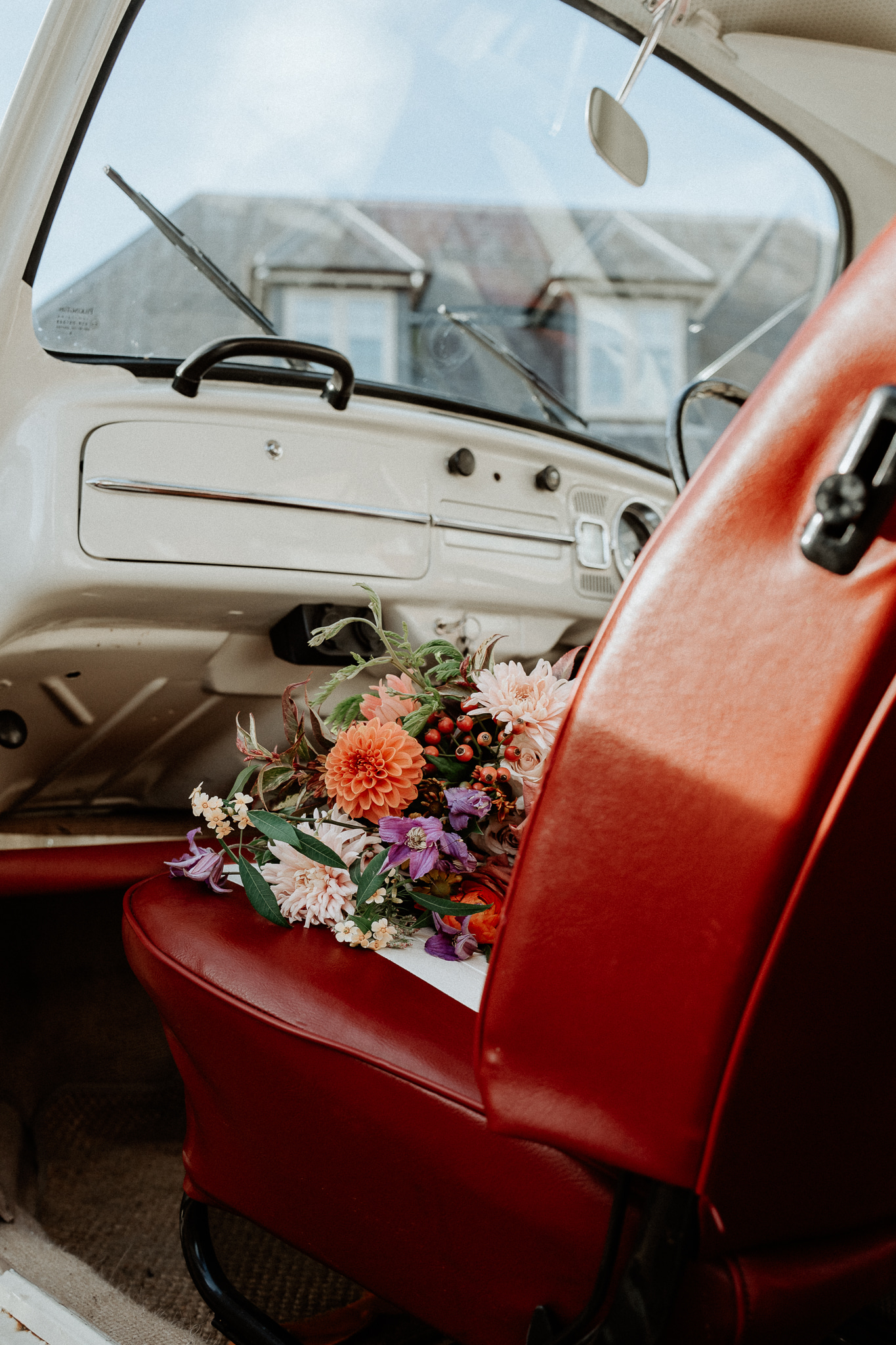 Bridal bouquet sitting on the front seat of a vintage VW camper.