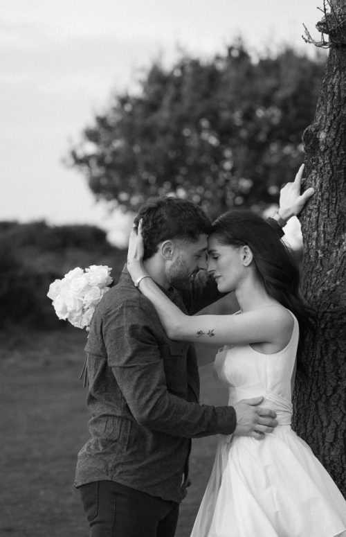 Couple in embrace leaning against a tree at Quantock Hills