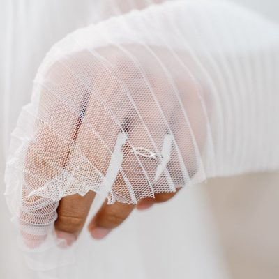 bridal wedding ring on hand under veil detail shot