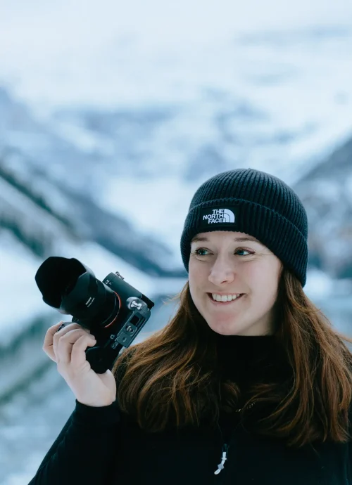 Portrait of Fran holding a camera up at Lake Louise.